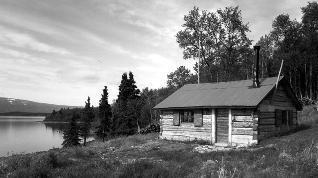 a rustic cabin on a hill above a lake